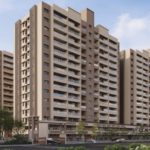 Exterior view of Kolte-Patil Springshire luxury residential towers in Wagholi Pune featuring modern L-shaped architecture with open spaces and greenery